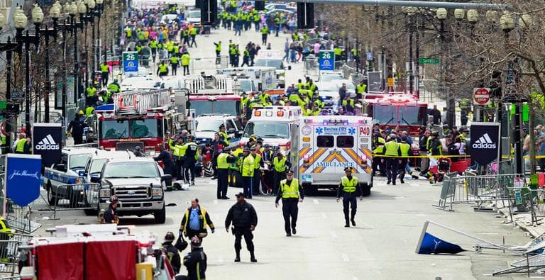 Police clear the area at the finish line of the 2013 Boston Marathon as medical workers help the injured following the explosions. (Charles Krupa/AP)