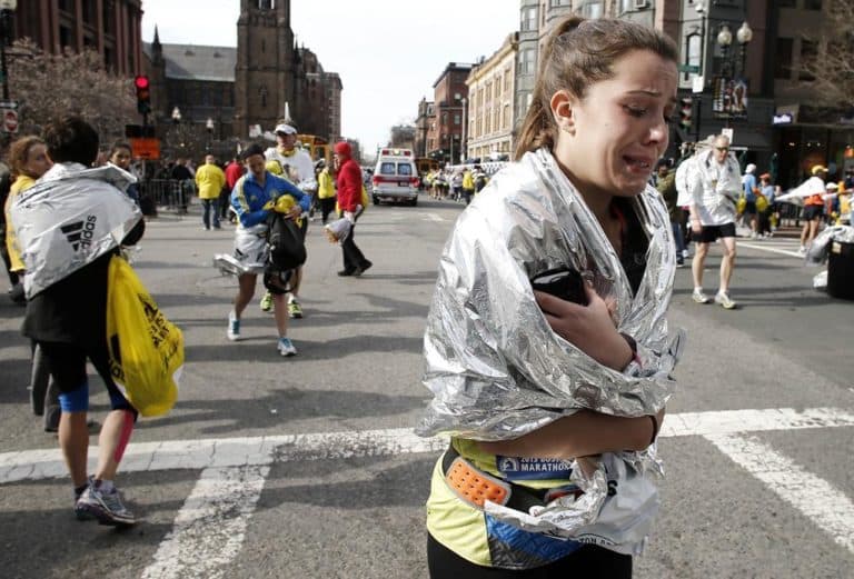 An unidentified Boston Marathon runner leaves the course crying near Copley Square following an explosion in Boston Monday, April 15, 2013. (Winslow Townson/AP)