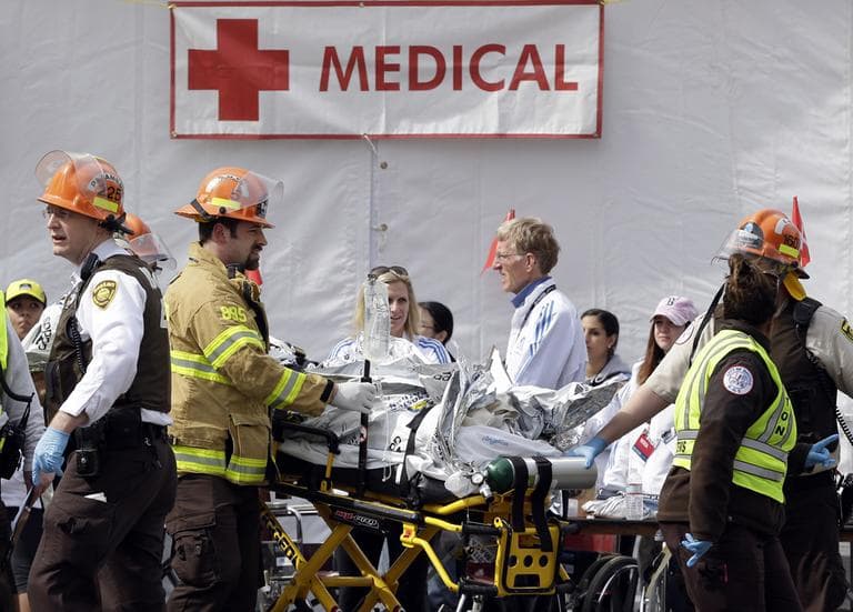 Medical personnel work outside the medical tent in the aftermath of two blasts which exploded near the finish line of the Boston Marathon in Boston, Monday, April 15, 2013. (Elise Amendola/AP)