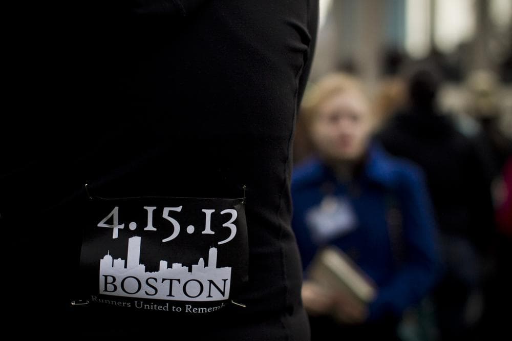 A runner wears a commemorative bib during a candle light vigil at the Boston Common a day after two explosions near the Boston Marathon finish line (Dominick Reuter/WBUR)