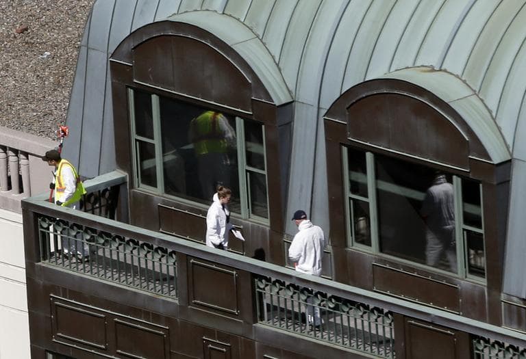 Investigators look through the top of a building on Boylston Street on Wednesday, two days after two bombs exploded just before the Boston Marathon finish line. (Julio Cortez/AP)