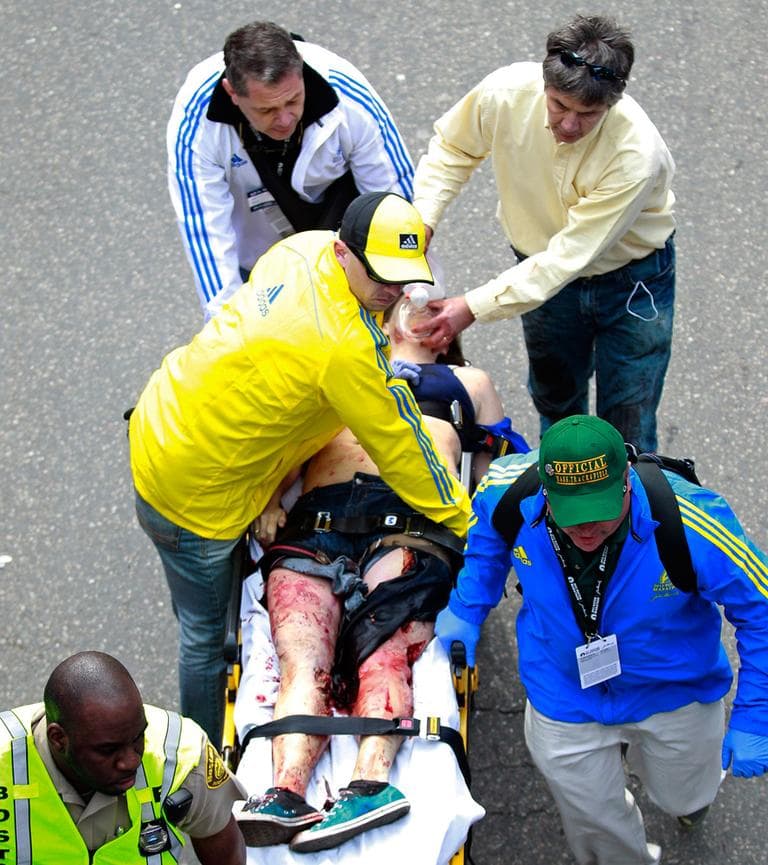 Rick Kates, in the blue jacket, is a trained EMT and a track coach at Notre Dame Academy in Hingham. He was working the marathon as an official when the first blast hit. (Charles Krupa/AP)