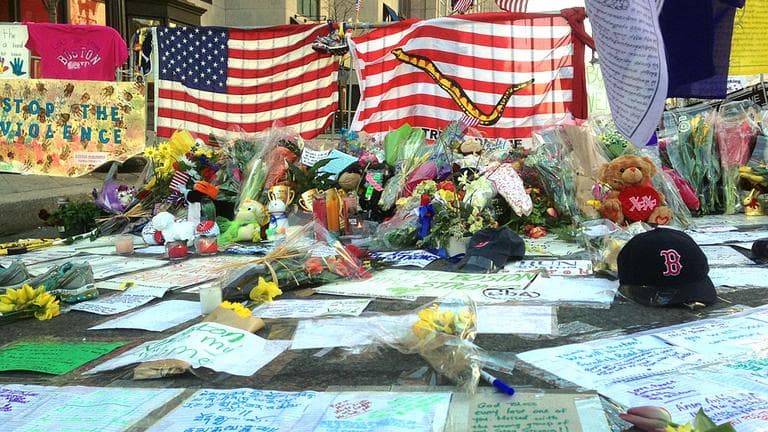 Flowers and banners at a memorial for the victims of the Boston Marathon bombings on Boylston Street Thursday. (Jesse Costa/WBUR)