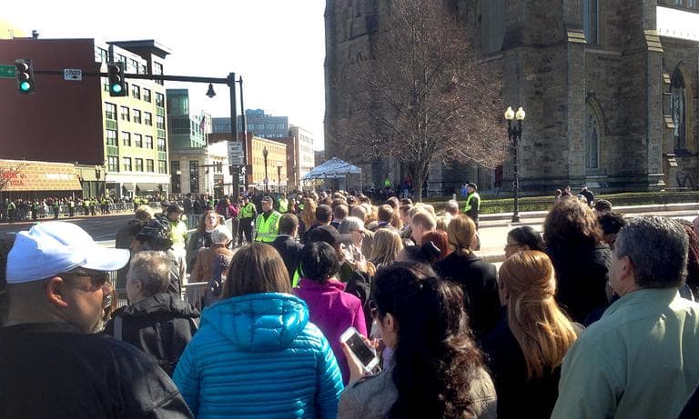 Ahead of the service, a crowd lines up outside the Cathedral of the Holy Cross in Boston’s South End Thursday. (Jesse Costa/WBUR)