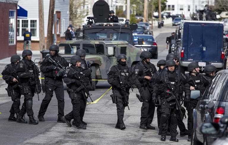 Heavily armed police patrol the neighborhoods of Watertown, Mass. Friday, April 19, 2013, as they continue a massive search for one of two suspects in the Boston Marathon bombing. (Craig Ruttle/AP)