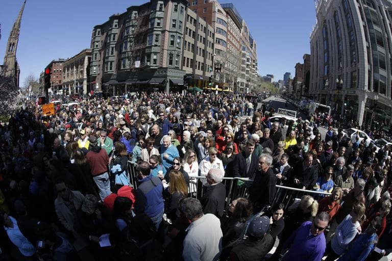 People attend an interfaith service held near a makeshift memorial on Boylston Street, near the finish line of the Boston Marathon on Sunday. (Julio Cortez/AP)