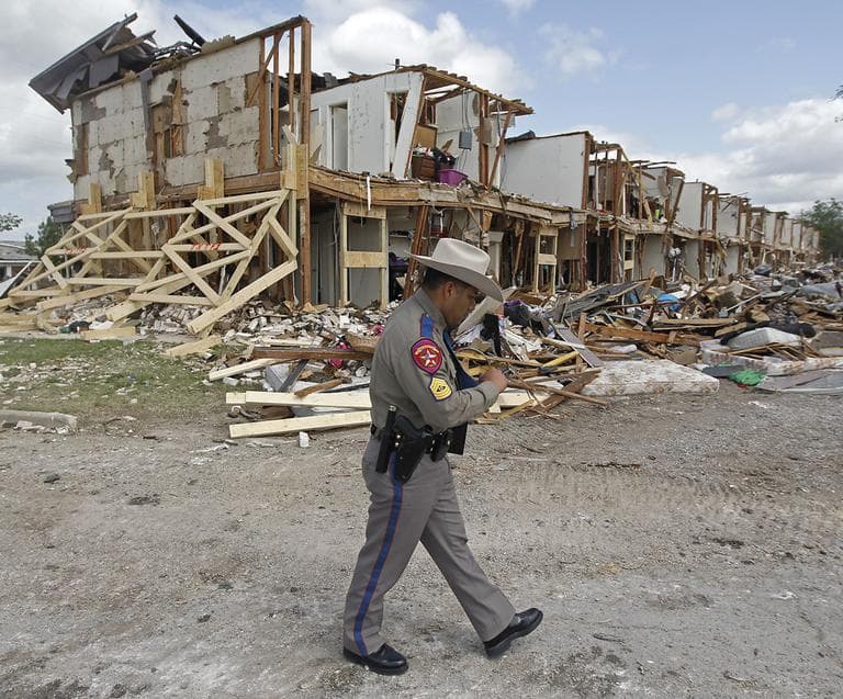 Texas Department of Public Safety Sgt. Jason Reyes walks past a damaged apartment complex, Sunday, April 21, 2013, four days after an explosion at a fertilizer plant in West, Texas. (Michael Ainsworth/The Dallas Morning News/AP)