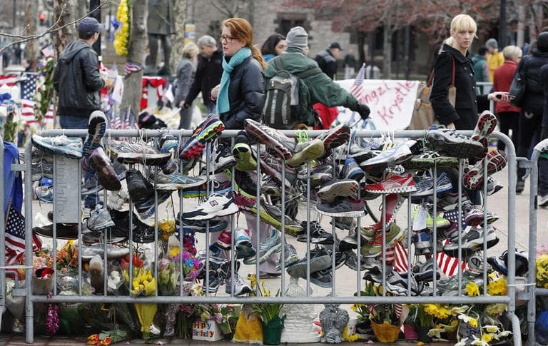 Running shoes hang from a barrier at a makeshift memorial in Copley Square on Wednesday. (Michael Dwyer/AP)