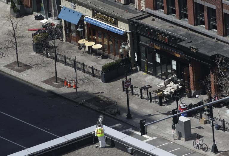 An investigator inspects the area near a surveillance camera on the roof of the Lord &amp; Taylor store, which, an official said, is crucial in the investigation of the explosions near the Boston Marathon finish line, Thursday, April 18, 2013, in Boston. (Julio Cortez/AP)