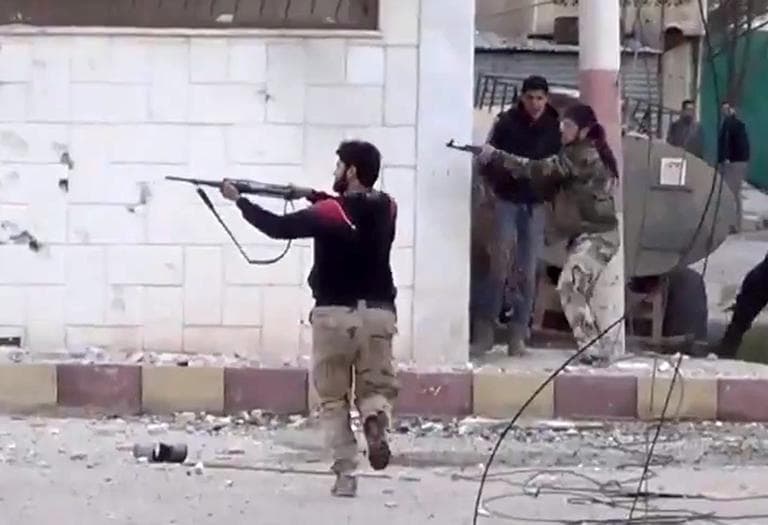 This image taken from video, which has been authenticated, shows free Syrian Army fighters fire at Syrian army soldiers during a fierce firefight in Daraa al-Balad, Syria, March 18, 2013. (Shaam News Network via AP)