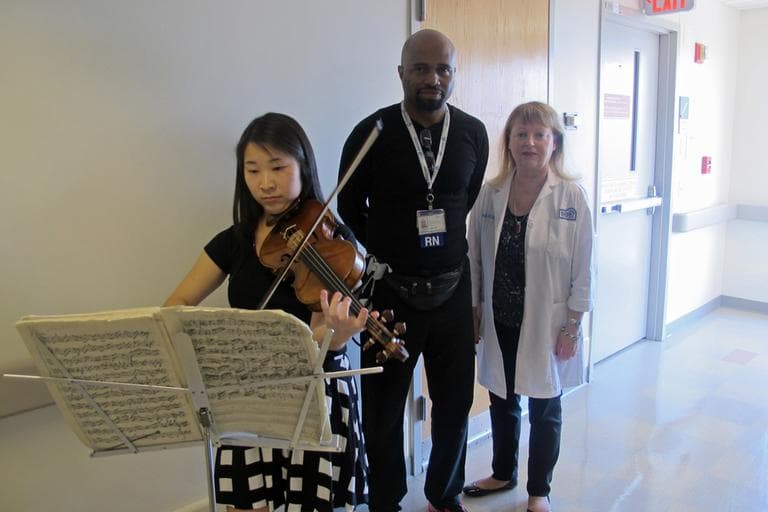 Ashley Ng (CFA '13) performs at Boston Medical Center. Nurses enjoy her music. Marilyn Joyce (far right) is the nurse manager. (Andrea Shea/WBUR)