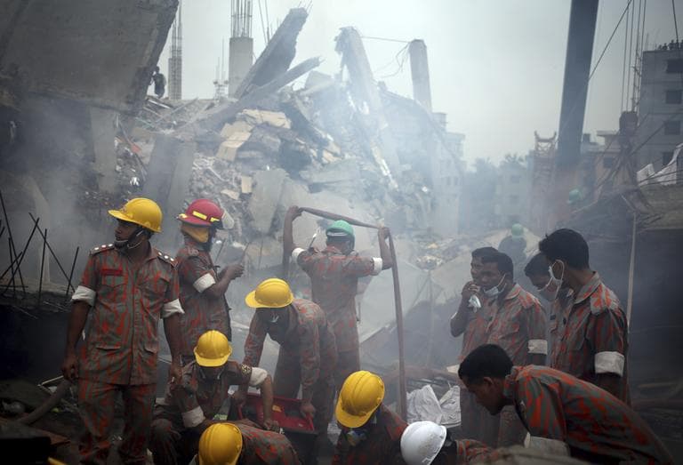 Workers and firefighters are shrouded in smoke as they prepare to dislodge the debris and fallen ceiling of the garment factory building in Savar, Bangladesh, on Monday, April 29, 2013. (Wong Maye-E/AP)