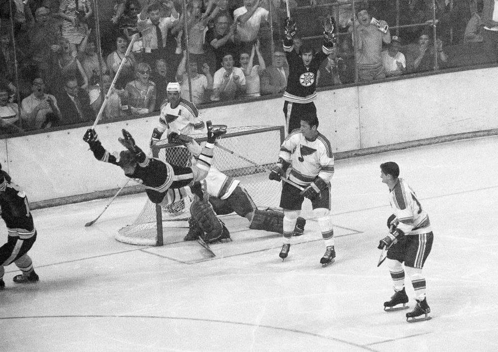 This May 10, 1970, file photo shows Boston Bruins' Bobby Orr flying through the air after scoring the winning goal past St. Louis Blues' goalie Glenn Hall, that clinched the Stanley Cup Championship, in Boston. Derek Sanderson, who set up the pass, cheers in the background. (A.E. Maloof/AP)