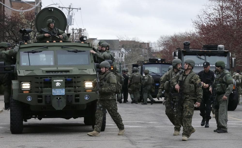 A SWAT team unloads from their armored vehicles as they go door to door while searching for a suspect in the Boston Marathon bombings in Watertown, Mass., Friday, April 19, 2013.Two suspects in the Boston Marathon bombing killed an MIT police officer, injured a transit officer in a firefight and threw explosive devices at police during their getaway attempt in a long night of violence that left one of them dead and another still at large Friday, authorities said as the manhunt intensified for a young man described as a dangerous terrorist. (AP Photo/Charles Krupa)