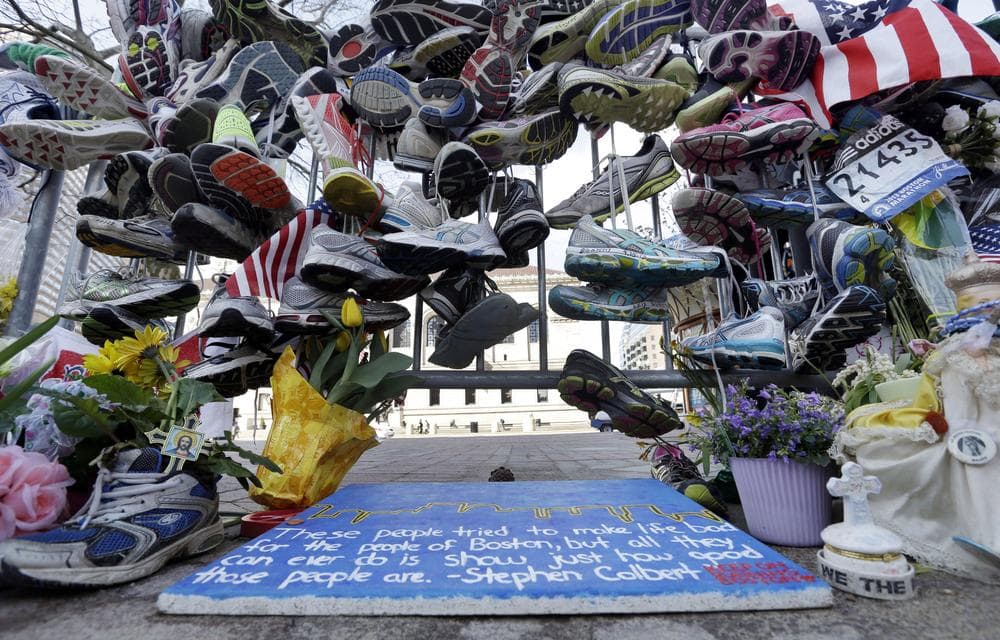 Running shoes hang on a fence at a makeshift memorial near the Boston Marathon finish line in Boston's Copley Square Thursday, April 25, 2013 in remembrance of the Boston Marathon bombings. (AP Photo/Elise Amendola)