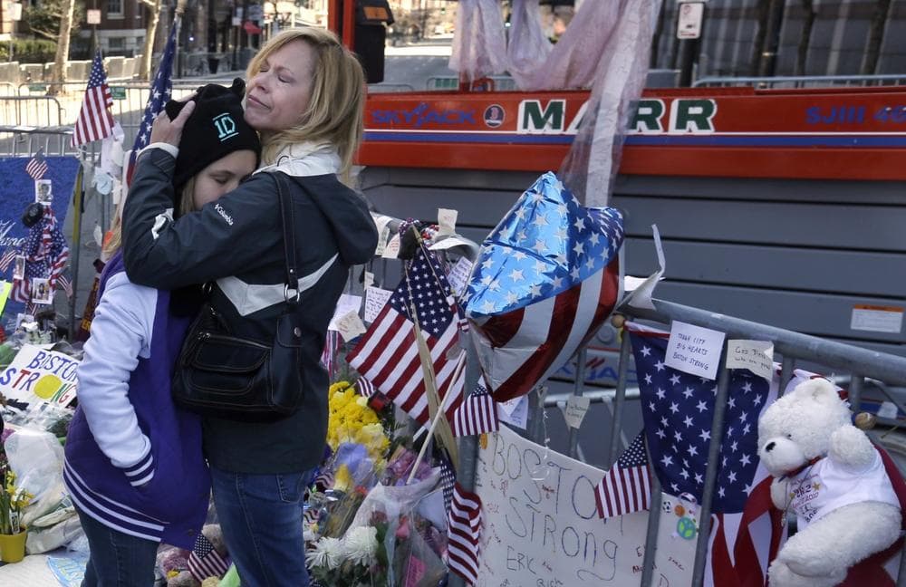 Holly Holland, right, of St. Louis, hugs her daughter Katie Holland while visiting a makeshift memorial in Boston, Monday, April 22, 2013. The memorial sits on Boylston Street, not far from where two bombs exploded near the finish line of the Boston Marathon, on Monday, April 15. (AP Photo/Steven Senne)