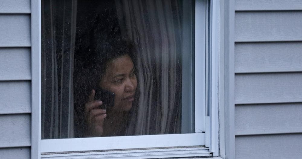 A woman looks out a window at her home as police start to search an apartment building while looking for a suspect in the Boston Marathon bombings in Watertown, Mass., Friday, April 19, 2013. Two suspects in the Boston Marathon bombing killed an MIT police officer, injured a transit officer in a firefight and threw explosive devices at police during their getaway attempt in a long night of violence that left one of them dead and another still at large Friday, authorities said as the manhunt intensified for a young man described as a dangerous terrorist. (AP Photo/Charles Krupa)