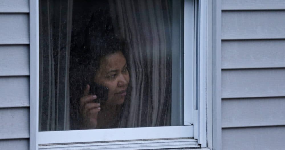 A woman looks out her window in Watertown during the manhunt for the surviving Boston Marathon bombing suspect, on April 19, 2013. (Charles Krupa/AP)