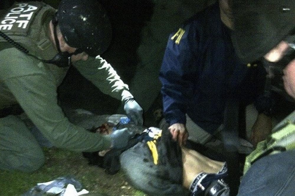 ATF and FBI agents check suspect Dzhokhar Tsarnaev for explosives and also give him medical attention after he was apprehended in Watertown, Mass. on Friday, April 19, 2013. (AP)