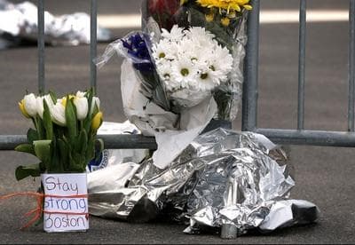 Flowers sit at a police barrier near the finish line of the Boston Marathon in Boston Tuesday, April 16, 2013. (AP Photo/Winslow Townson)