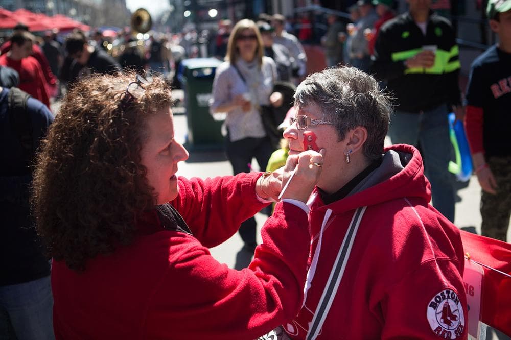 Patty Sorrell paints the face of Priscilla Allegia before the game. (Jesse Costa/WBUR)