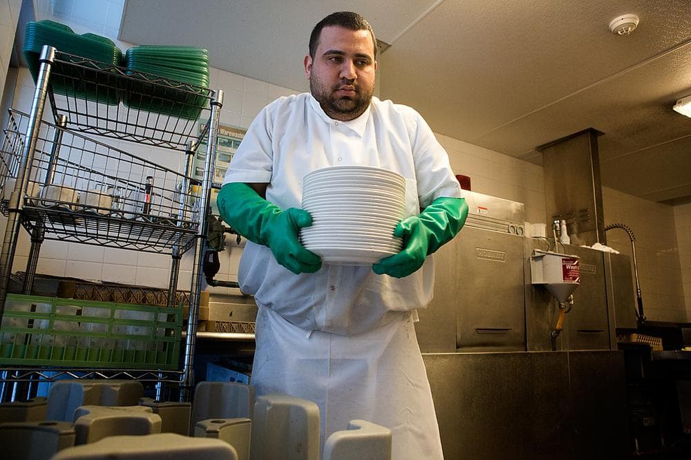 Anas al-Hamdani moves clean dishes into the dining hall at MIT's Simmons Hall. (Jesse Costa/WBUR)