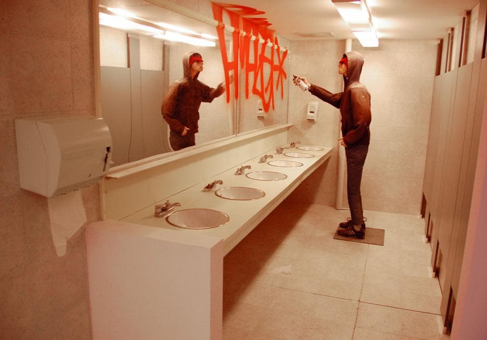 An animatronic John Lazcano sprays “Amaze*” on a bathroom mirror in this 2005/2012 McGee installation. (Greg Cook)
