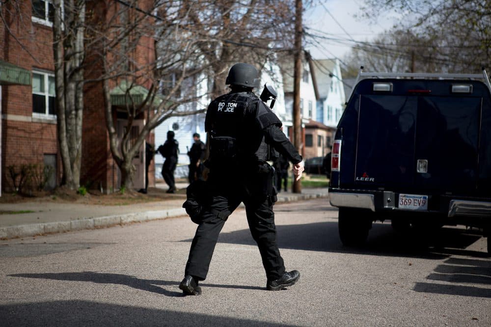 Officers looking for Dzhokhar Tsarnaev move in to search an apartment building on Melendy Avenue in Watertown in 2013. (Jesse Costa/WBUR)