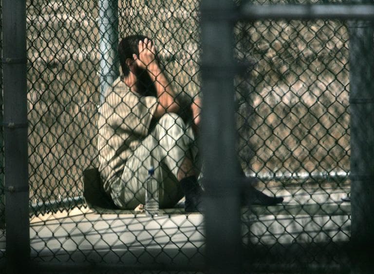 A Guantanamo detainee sits alone inside a fenced area during his daily outside period, at Guantanamo Bay U.S. Naval Base, Cuba. (Brennan LinsleyAP)