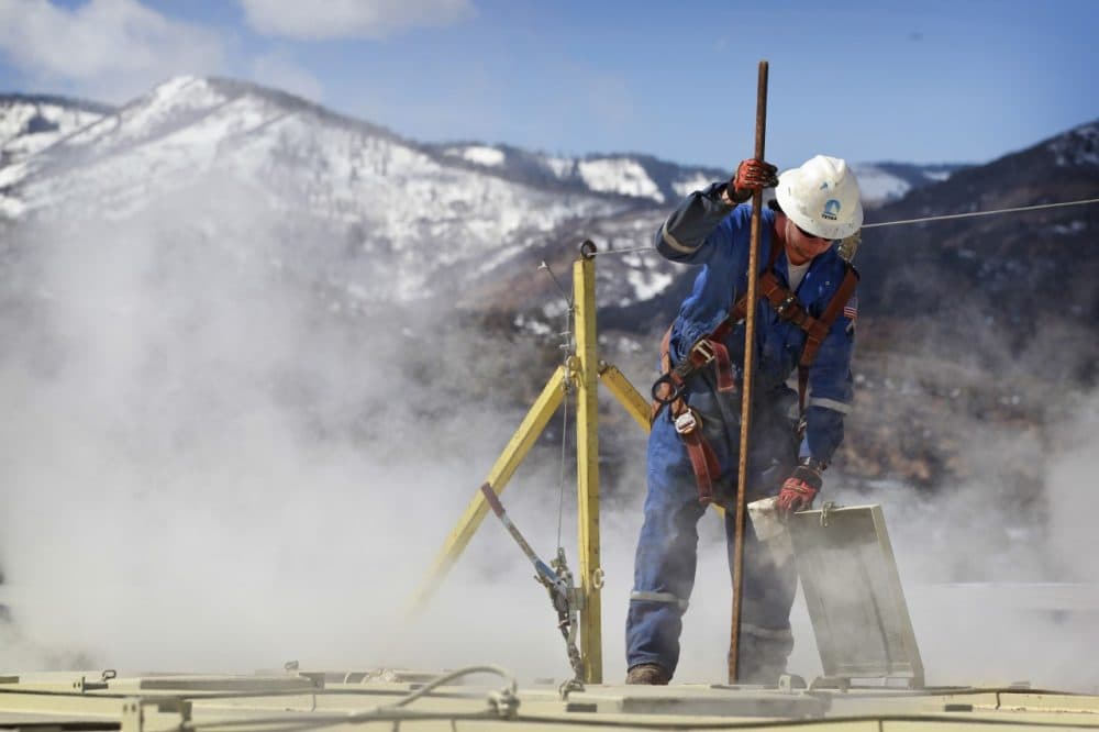 A worker checks a dipstick at an Encana Oil &amp; Gas (USA) Inc. hydraulic fracturing operation at a gas drilling site outside Rifle, Colorado. (AP)