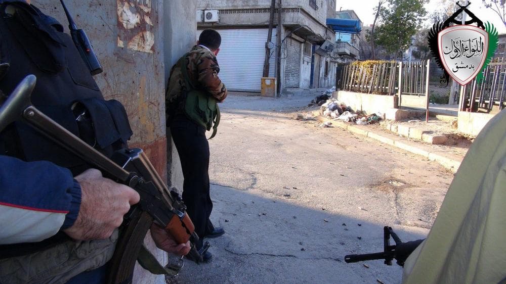 This citizen journalism image shows Syrian rebels taking cover in the the Barzeh district of Damascus, Syria, April 26, 2013. (Local Council of Barzeh via AP)