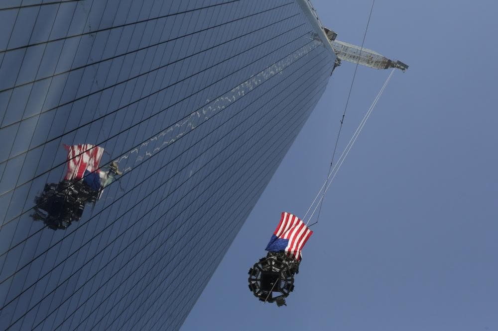 The final piece of spire was hoisted to the roof of One World Trade Center Thursday in New York City. The piece will be attached to the spire at a later date, capping off the tower at 1,776 feet. (Mark Lennihan/AP)