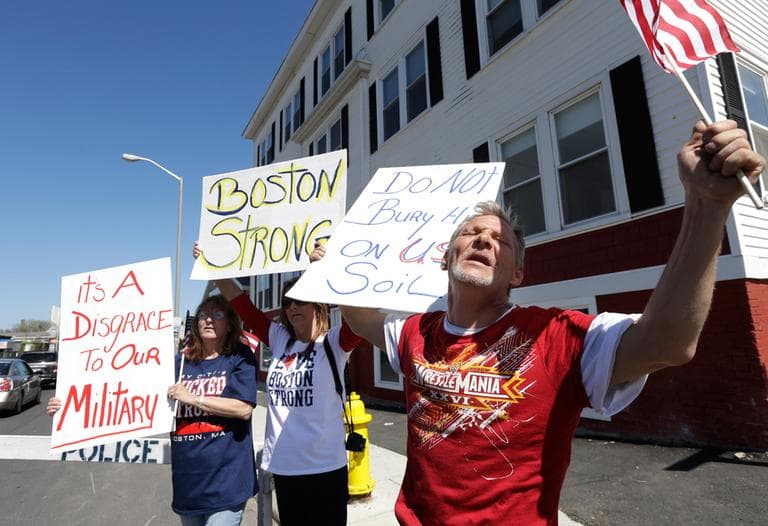 Herbert Robbins, of Worcester, Mass., right, joins with other demonstrators as they display placards and chant slogans on the street outside the Graham, Putnam, and Mahoney Funeral Parlors, in Worcester, May 5, 2013. (Steven Senne/AP)