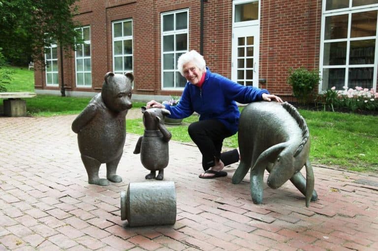 Public artist Nancy Schön poses with Eeyore, Winnie the Pooh and newly added Piglet outside Newton Public Library. (Courtesy of Jacki Schon)