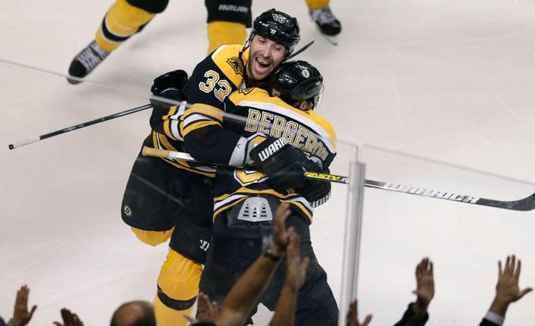 Boston Bruins center Patrice Bergeron (37) is embraced by teammate Zdeno Chara after scoring the game-winning goal against the Toronto Maple Leafs during overtime in Game 7 of their NHL playoff series, in Boston Monday. (Charles Krupa/AP)