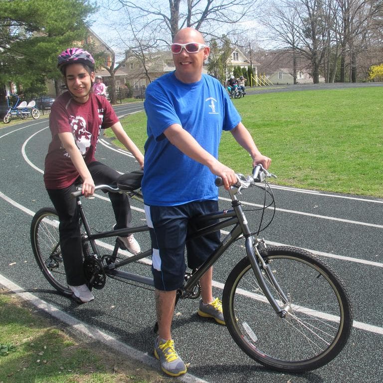 Lina rides a tandem bicycle with her instructor. (Andrea Shea/WBUR)