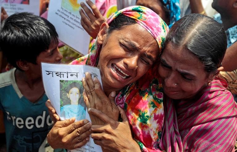 A Bangladeshi woman cries holding the portrait of a missing relative as they gather to offer prayers for the souls of the 1,127 people who died in the garment building structure collapse last month, in Savar, near Bangladesh, Tuesday, May 14, 2013. (A.M. Ahad/AP)