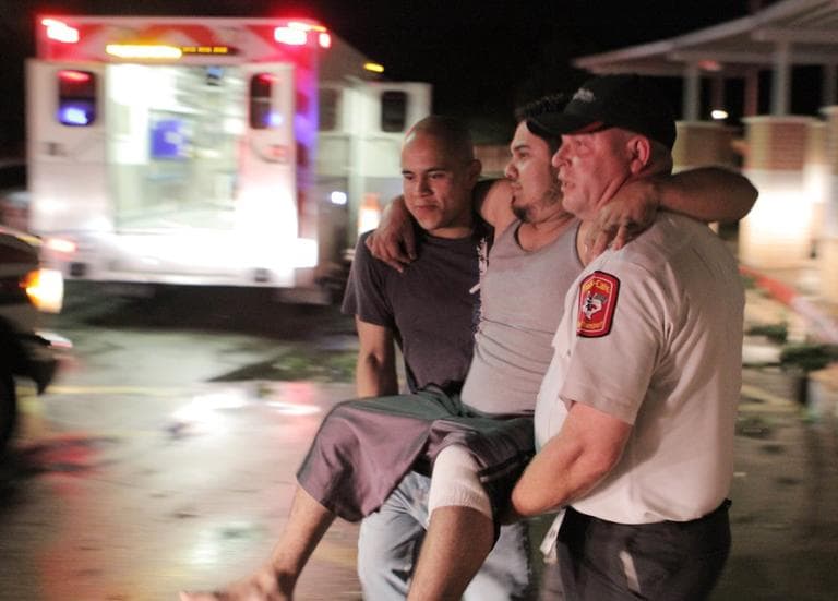 Johnny Ortiz, left, and James South, right, carry Miguel Morales, center, who was injured in a tornado, to an ambulance in Granbury, Texas, on Wednesday May 15, 2013. (Mike Fuentes/AP)