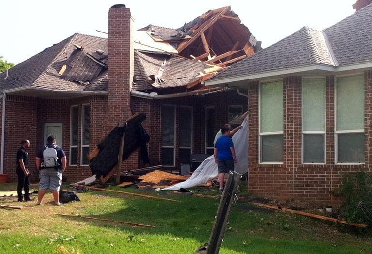 Residents of Edmond, Okla., survey storm damage from a tornado that hit their neighborhood Sunday, May 19, 2013. (Sean Murphy/AP)