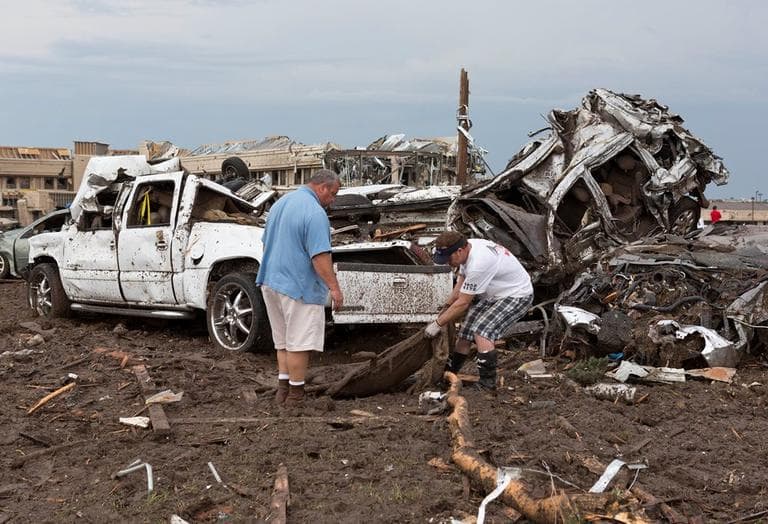 Two men go through the damage surrounding the Moore Medical Center and damaged vehicals after a tornado moves through Moore, Okla. on Monday, May 20, 2013. (Alonzo Adams/AP)