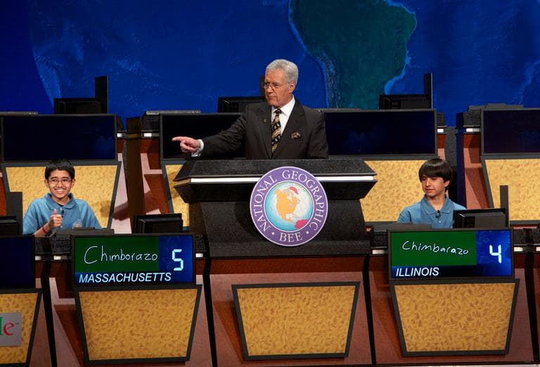In this image released by National Geographic, bee winner Sathwik Karnik, left, of Massachusetts, gives a thumbs-up as he correctly answers the final question posed by moderator Alex Trebek on Wednesday. Runner-up Conrad Oberhaus, of Illinois, watches at right. (Rebecca Hale, via AP)