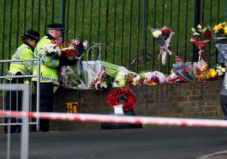 Police officers lay down floral tributes handed to them by members of the public at the scene of a terror attack in Woolwich, southeast London, Thursday, May 23, 2013.(Sang Tan/AP)