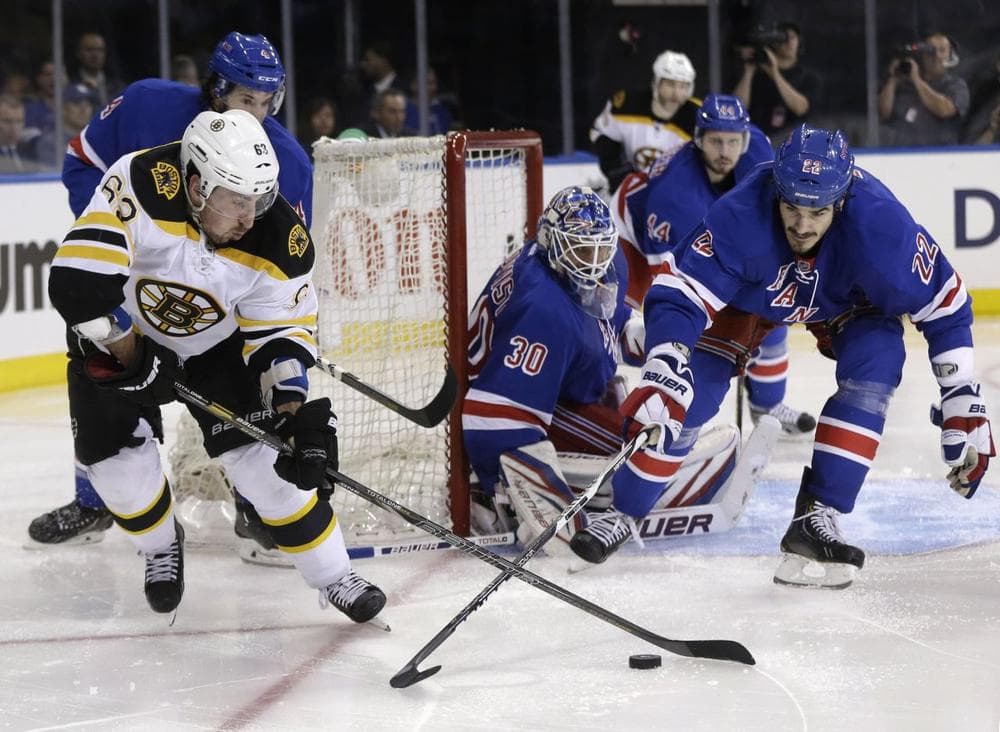 Bruins' Brad Marchand, left, and New York Rangers' Brian Boyle, right, fight for the puck. (AP/Seth Wenig)