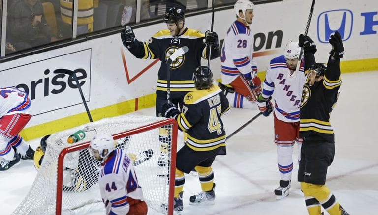 Boston Bruins center Gregory Campbell falls behind the goal as his teammates celebrate after his goal against the New York Rangers during the second period in Game 5 of the Eastern Conference semifinals in the NHL hockey Stanley Cup playoffs in Boston, Saturday, May 25, 2013. (Charles Krupa/AP)