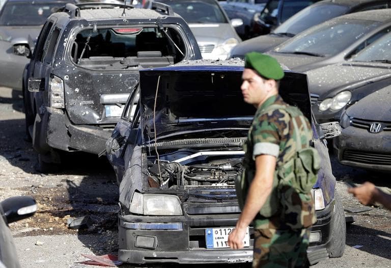 A Lebanese army soldier stands guard in front of damaged cars where a rocket struck a car exhibit at the Mar Mikhael district, south of Beirut, Lebanon, Sunday May 26, 2013. (Hussein Malla/AP)