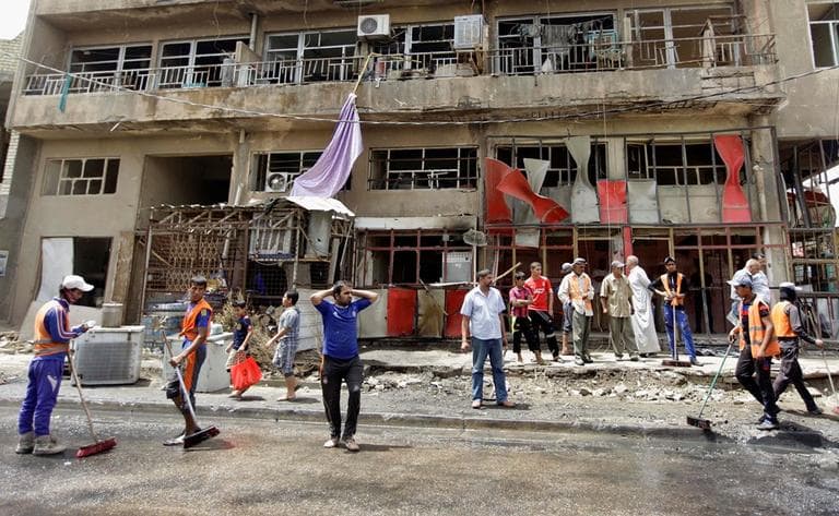 Baghdad municipality workers clean up while restaurant staff react after a parked car bomb exploded near the popular restaurant in the Ur neighborhood in northern Baghdad, Iraq, Thursday, May 30, 2013. (Khalid Mohammed/AP)