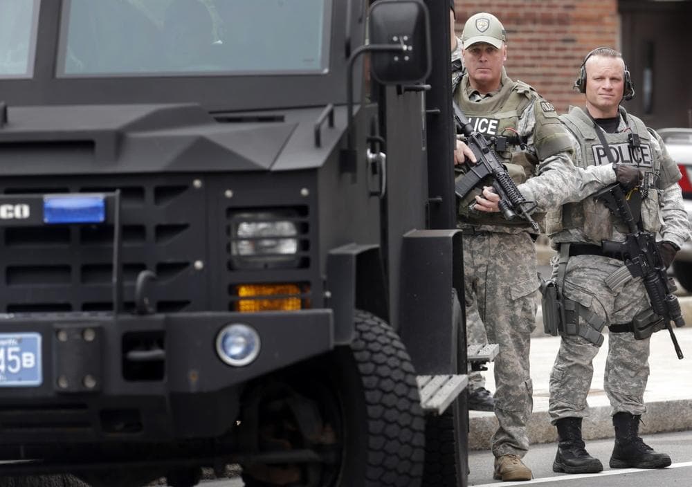 Members of a police SWAT team hold rifles while standing next to an armored vehicle outside an entrance to a memorial service for fallen Massachusetts Institute of Technology police officer Sean Collier, in Cambridge, Mass., Wednesday, April 24, 2013. Collier was fatally shot on the MIT campus Thursday, April 18, 2013. Authorities allege that the Boston Marathon bombing suspects were responsible. (AP Photo/Steven Senne)