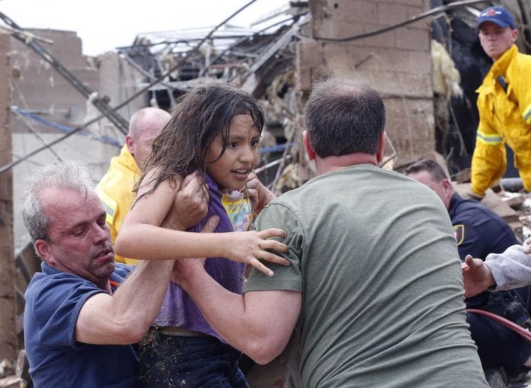A child pulled from the rubble of the Plaza Towers Elementary School in Moore, Okla., and passed along to rescuers in Moore. (Sue Ogrocki/ AP)