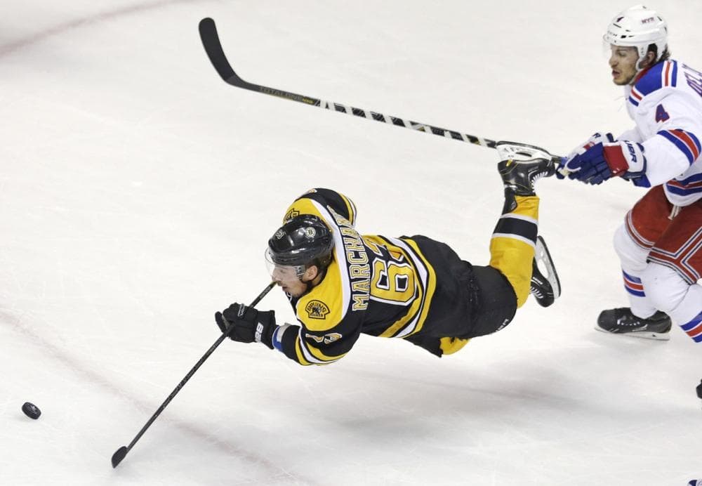 Boston Bruins left wing Brad Marchand (63) is tripped as he shoots on-goal after getting past New York Rangers defenseman Michael Del Zotto (4) during the second period in Game 1 of an NHL hockey playoffs Eastern Conference semifinal game in Boston, Thursday, May 16, 2013. (Charles Krupa/AP)