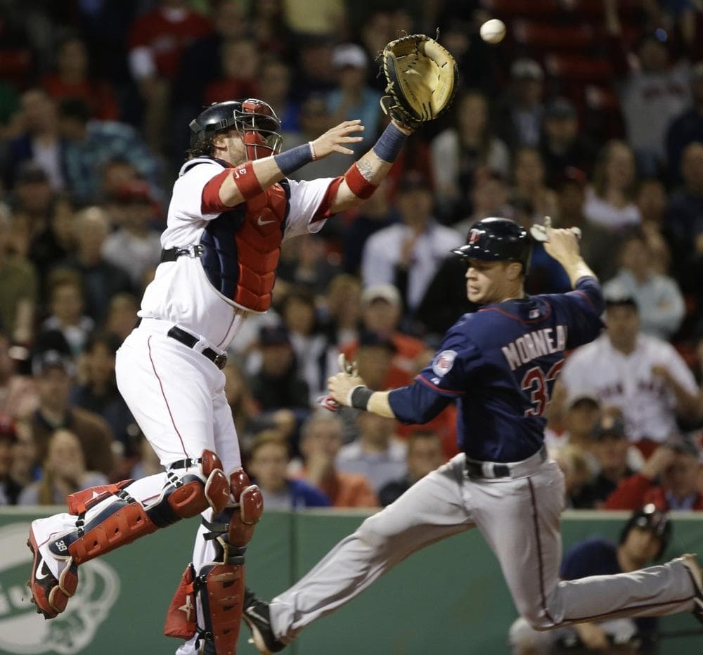 Boston Red Sox catcher Jarrod Saltalamacchia reaches for a high throw as Minnesota Twins' Justin Morneau slides in to score on a grounder by Ryan Doumit during the eighth inning of a baseball game at Fenway Park in Boston, Tuesday, May 7, 2013. (AP Photo/Elise Amendola)